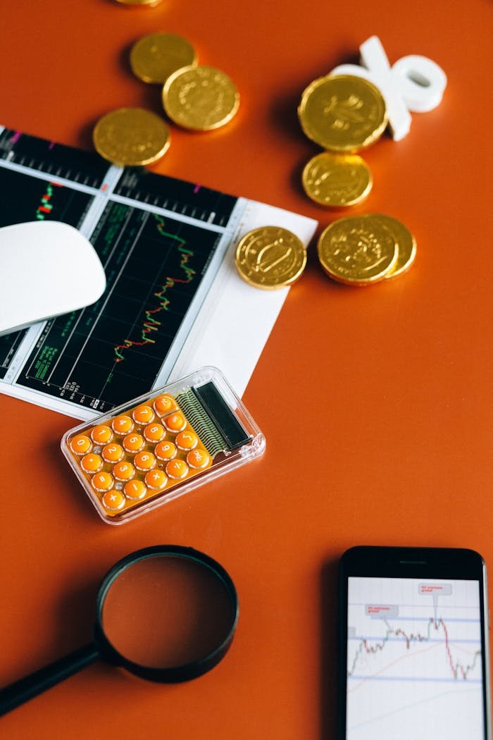 Stock market and financial analysis setup with calculator, graphs, and gold coins.